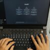 Hands typing on a laptop with ChatGPT open.