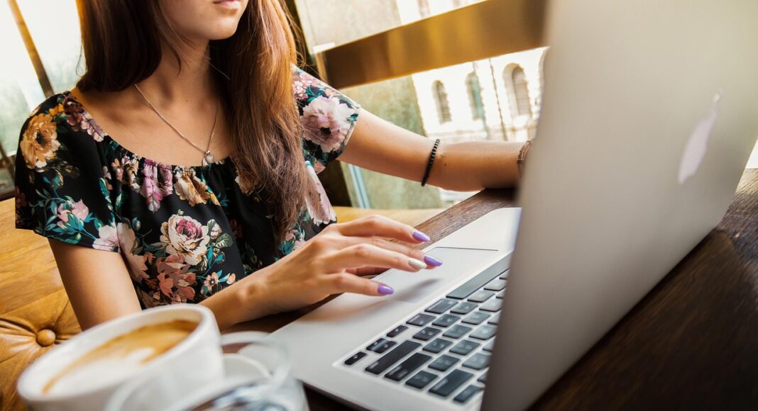 A young woman typing on a laptop.