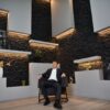 A businessman in a suit sitting confidently in a modern office setting.