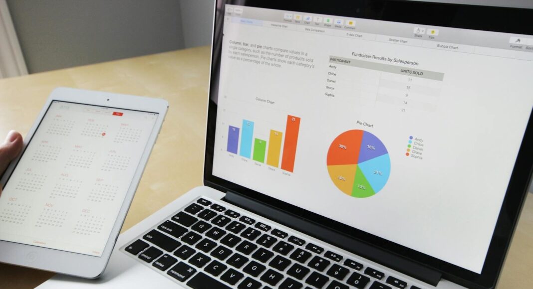 Laptop displaying charts and graphs with tablet calendar for data analysis and planning.