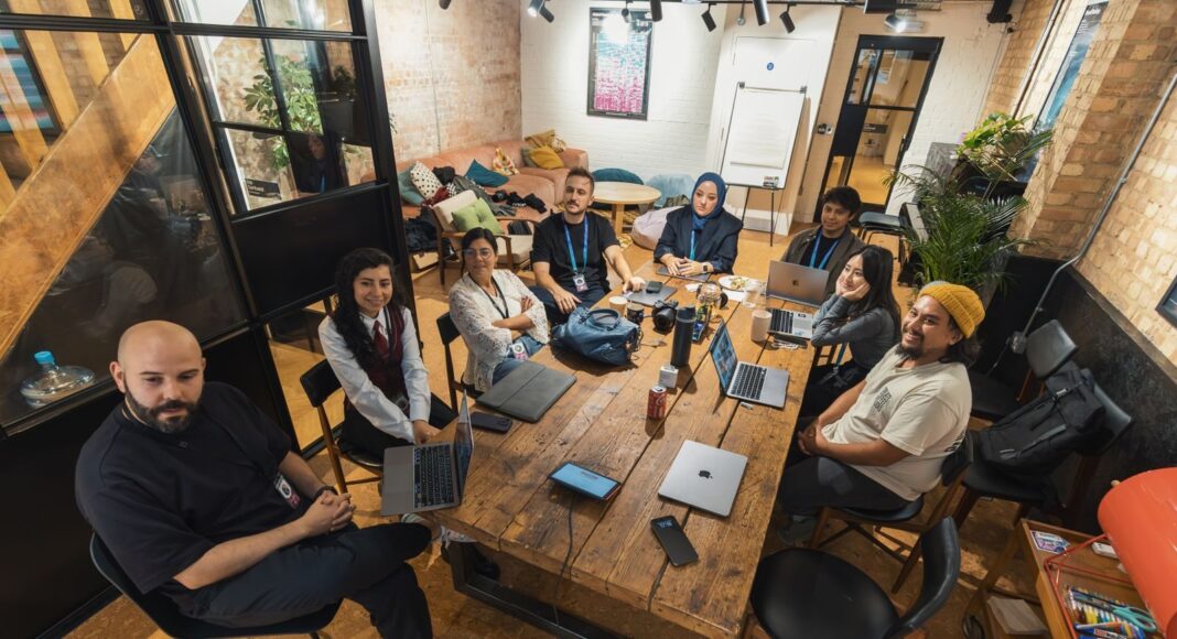 Photo by Matheus Bertelli A group of diverse professionals collaborating in a modern office setting with laptops and technology.
