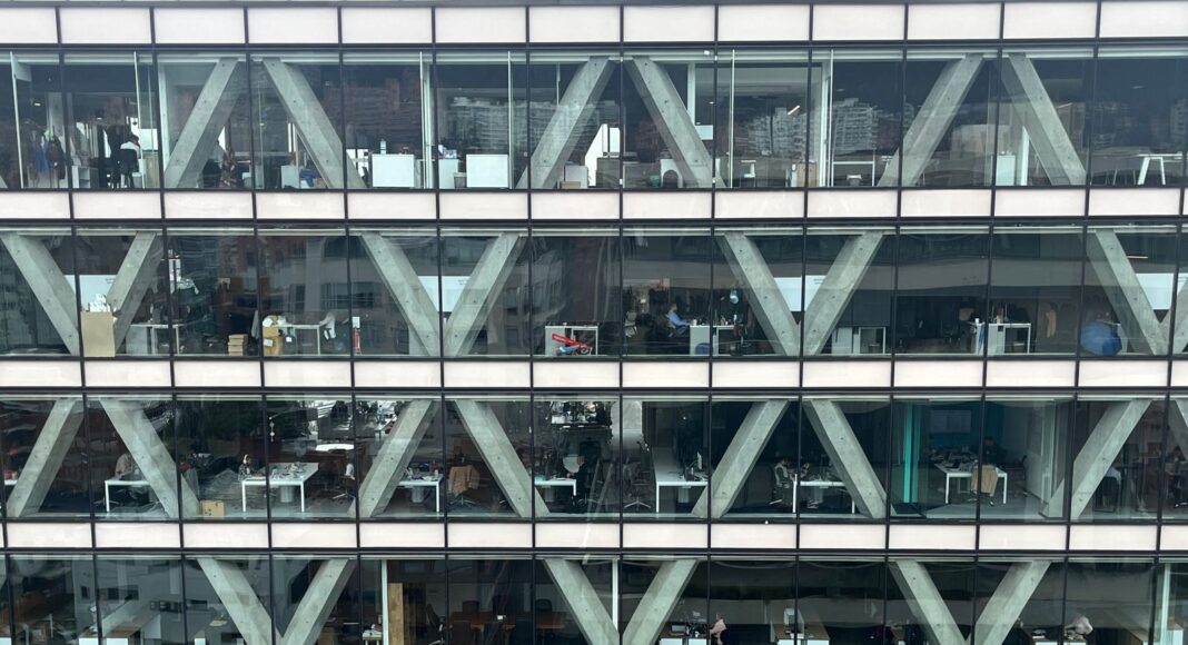 Photo by David Munoz Office building facade with glass windows.