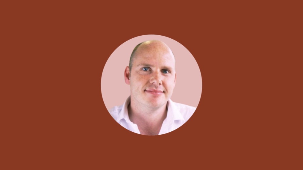 A bald man wearing a white shirt is shown in a circular frame against a solid brown background, representing Human Resources personnel.