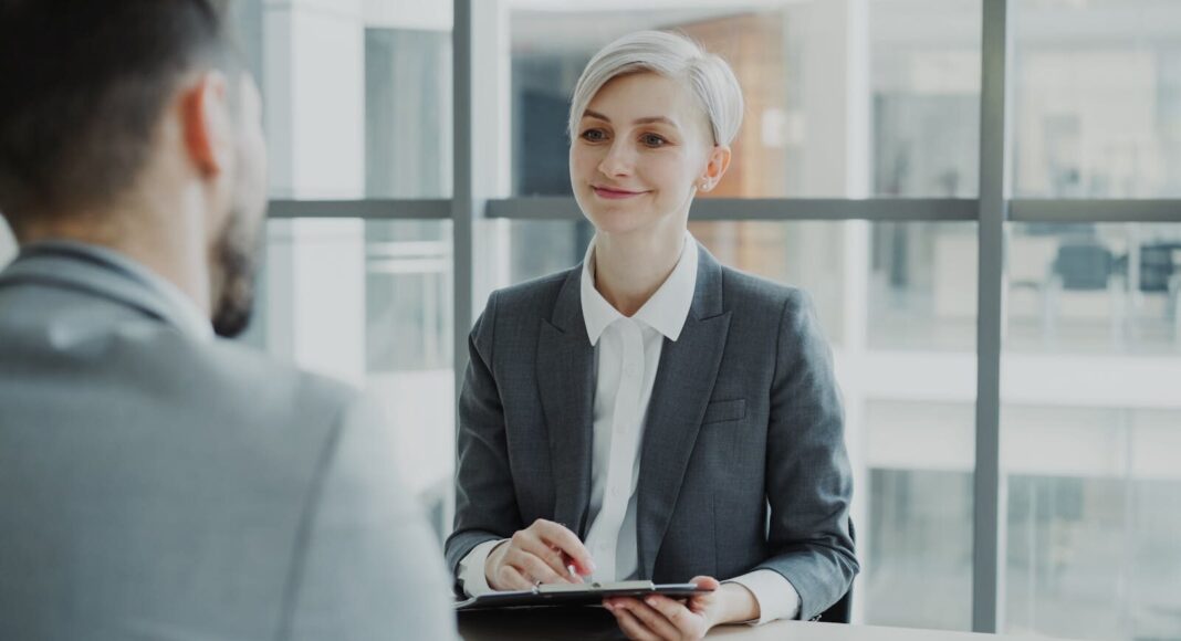 A woman interviewing a candidate in a modern office.