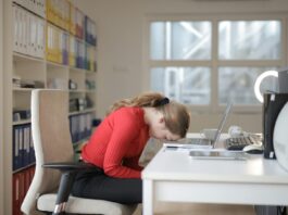 Burnout drives workers to value balance over pay A woman at her work desk rests her head on the table, suggesting burnout.