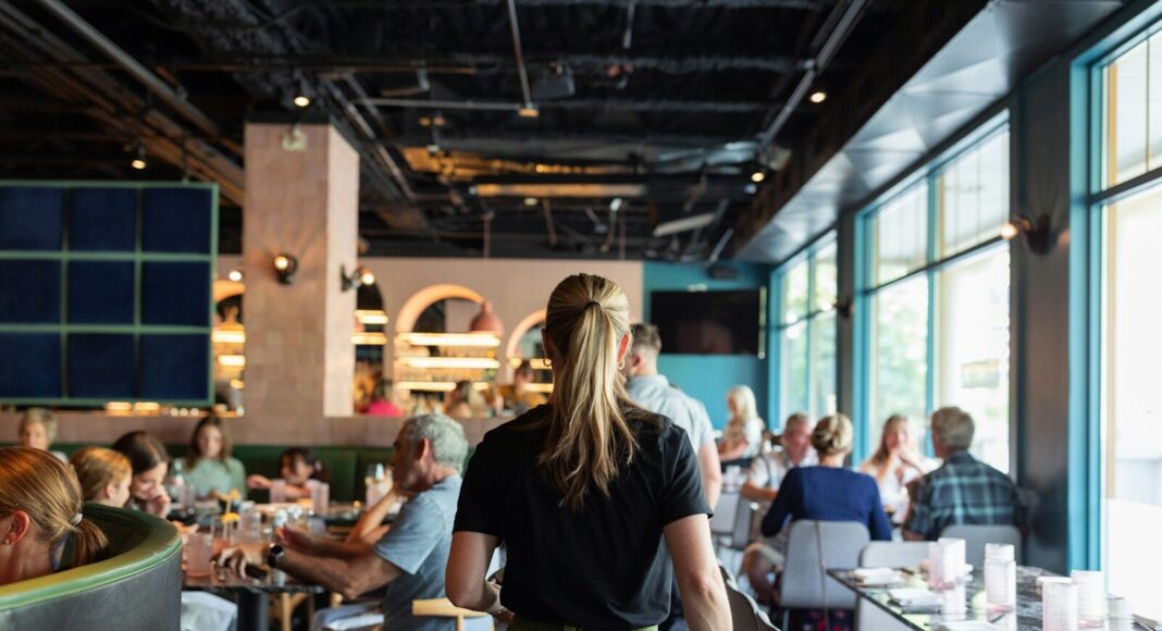 A waitress walks to a table of diners at a restaurant.