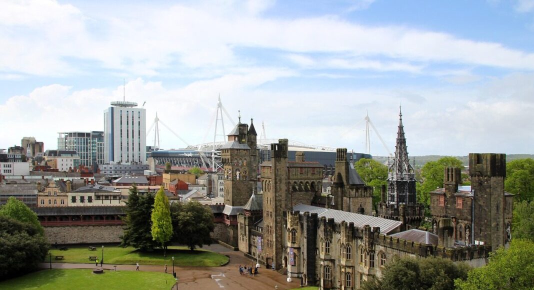 A view of an area of Cardiff, with a castle in the foreground and tall buildings in the background.