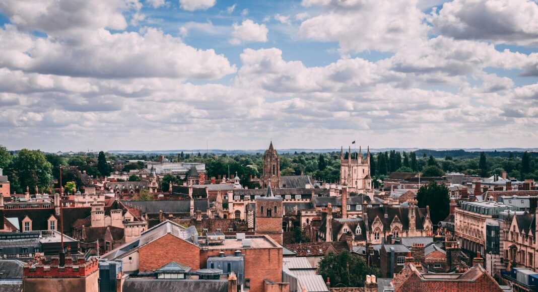 Brown and white concrete buildings under white clouds during daytime.