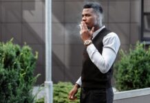 Smoking and vaping breaks ‘cost hours of working time each week’ A stylish young man smoking a cigarette outside an urban building.