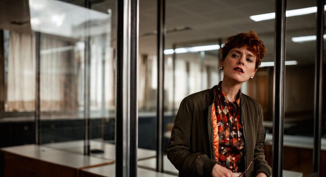 A woman standing in the door of a room in an office.
