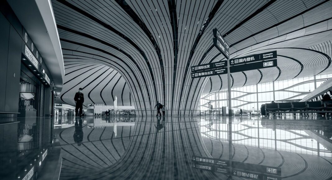 A black and white shot of the interior of an airport.