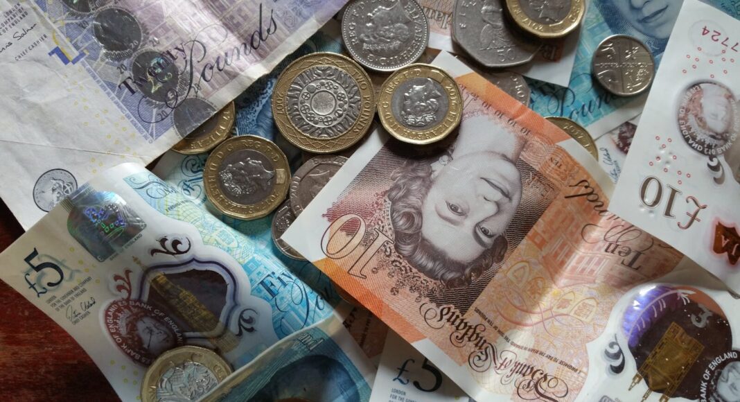 Close-up collection of British Pound notes and coins, showcasing UK currency.