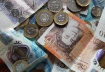 Hundreds of employers exposed for underpaying staff in £7.3m wage scandal Close-up collection of British Pound notes and coins, showcasing UK currency.