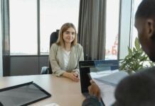 Job adverts list legal rights like holidays as workplace ‘perks’ A young woman sitting confidently in a modern office for a job interview.
