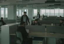 Public fears AI job losses as entry-level roles come under pressure People working in an darkened open-plan office.