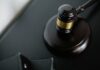 Worker fired over toilet vape row wins £22,000 unfair dismissal payout Close-up of a wooden judge's gavel on a black desk, symbolising justice and law.