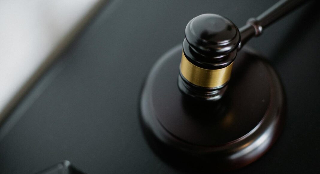 Close-up of a wooden judge's gavel on a black desk, symbolising justice and law.