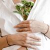 A woman clutching flowers to her chest, signalling pregnancy loss.