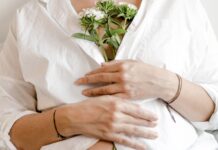 One in 10 women quit work after pregnancy loss, report finds A woman clutching flowers to her chest, signalling pregnancy loss.