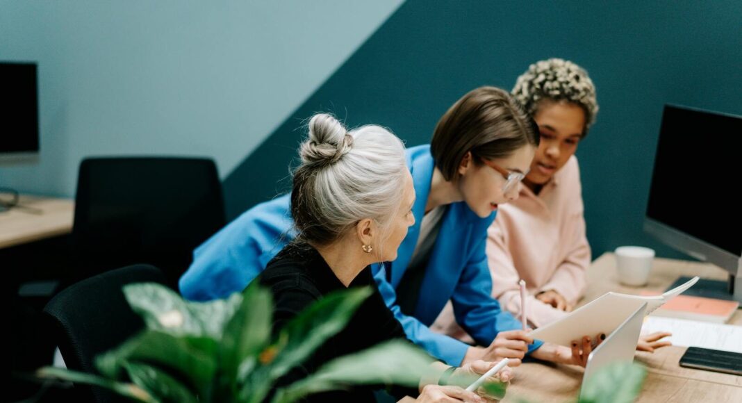 A diverse group of professionals collaborate on a project in a modern office environment.