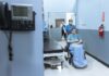 NHS badge review raises wider questions about political expression at work A nurse wheels a patient in a wheelchair down a hospital corridor, reflecting care and medical professionalism.