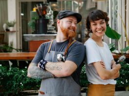 Optimism rises among UK workers but retirement fears persist A man and woman smiling at work.