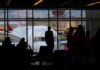 Expat jobs ‘fail early as costs hit $79,000 per worker’ Silhouettes of travelers waiting at an airport terminal with an airplane visible through the window.