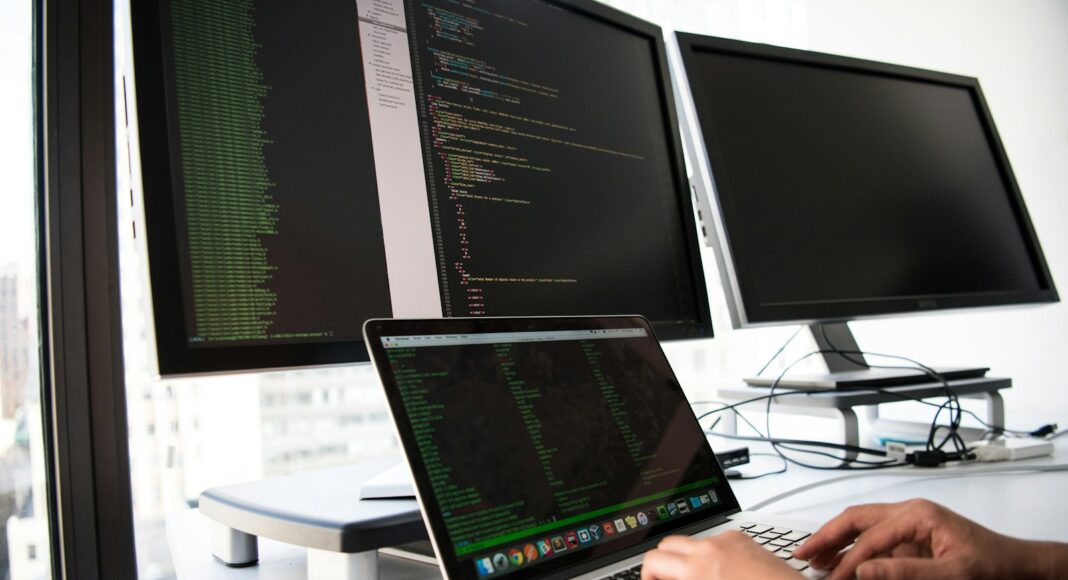 A person working on a computer with several screens.