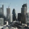Various shaped modern skyscrapers with glass mirrored facades located in financial district of London against blue sky on sunny day