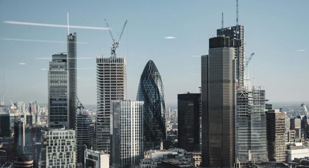 Various shaped modern skyscrapers with glass mirrored facades located in financial district of London against blue sky on sunny day