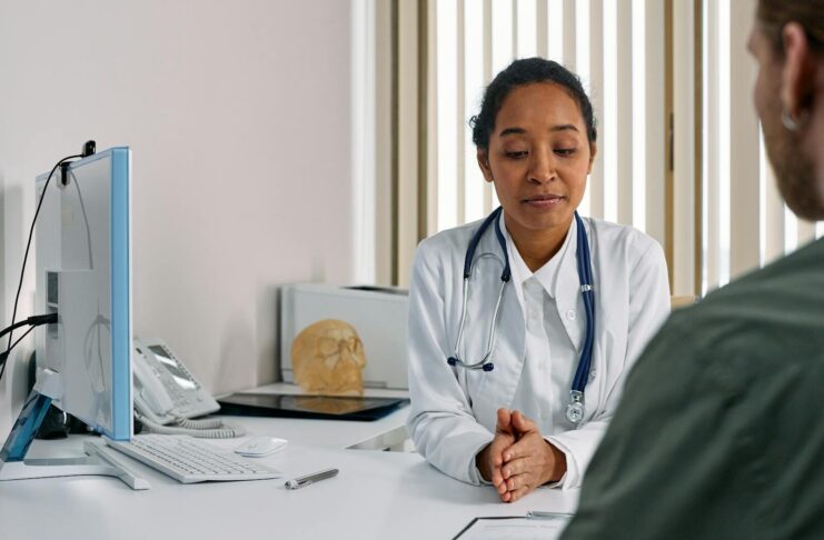 A female doctor consulting a patient in a modern medical office setting.