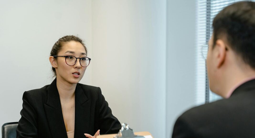 A man interviews a young woman for a job.