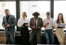 Unemployment set to top two million as energy shock hits UK jobs market A diverse group of colleagues using mobile devices in an office setting.