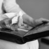 Close-up of hands holding a photo album and tissue, evoking memories.