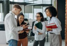 Youth unemployment set to hit 17.8 percent, business group warns Four young colleagues engage in a collaborative discussion in a modern office setting.