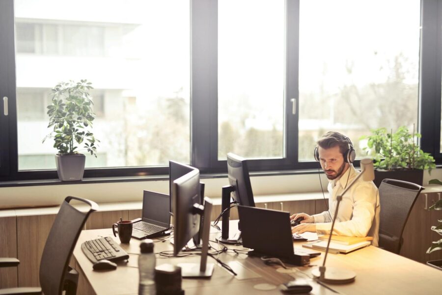 A man works on a computer in an open-plan office.
