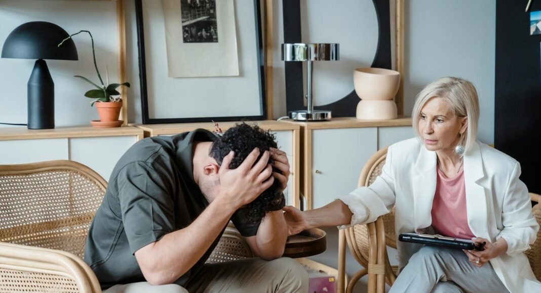 A supportive therapist provides comfort during a counseling session in a cozy office.