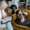 A therapist conducts a session with a client discussing mental health in a cozy office setting.