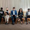 People sitting on chairs waiting to be interviewed for a job.