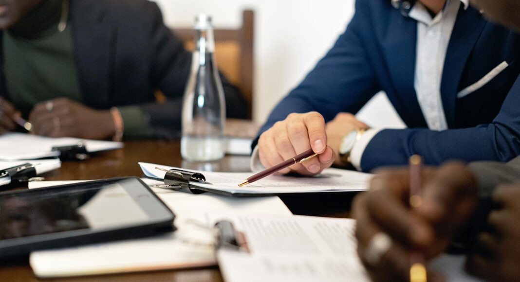 Photo by Mikhail Nilov Business meeting with adults discussing and signing contracts over a table.