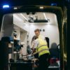 Paramedics attend to a patient inside an ambulance, providing emergency medical assistance at night.