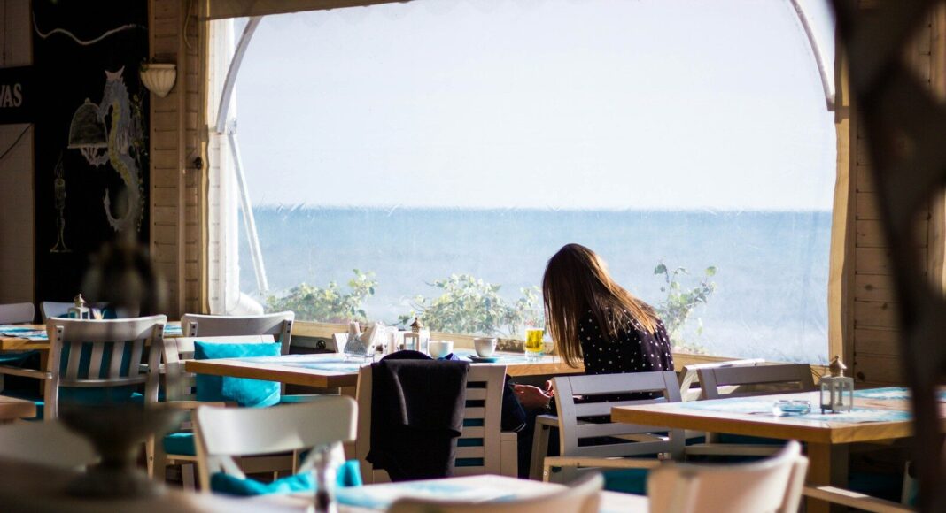 A woman sitting in a beach cafe.