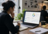 AI Coaching Won’t Replace Managers. It Will Expose Coaching Debt. A woman looks at a computer screeen in an office.