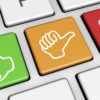 Close-up of a keyboard with three distinct buttons: a green thumbs-up, an orange thumbs-sideways, and a red thumbs-down, perfect for HR personnel to quickly provide feedback or ratings.