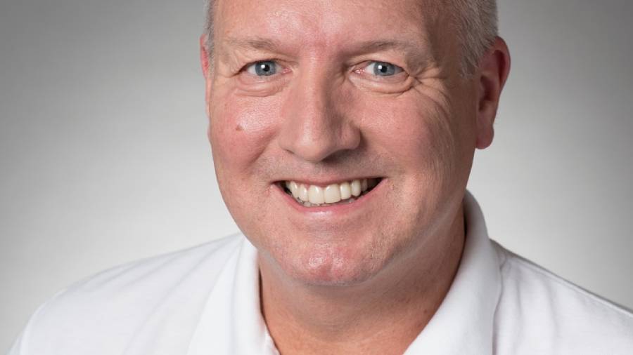 A man with short gray hair, from Human Resources, smiles at the camera, wearing a white collared shirt against a plain background.