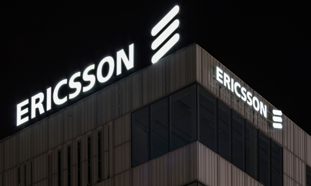 Nighttime view of a modern building with the Ericsson logo and name prominently displayed on its exterior, casting a shadow over recent ethics breaches.