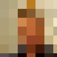 A man in a blue shirt smiling in front of a window.