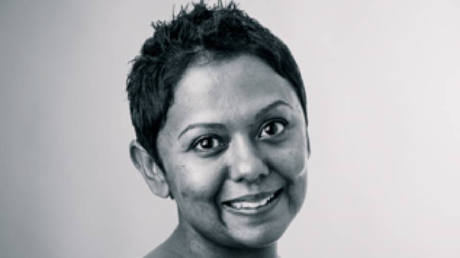 A black and white portrait of a person with short hair, smiling at the camera against a plain background, exuding confidence and approachability—perfect for a Human Resources professional.