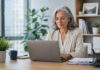 Menopause support gaps push women out of jobs as ‘masking’ takes toll An older woman works at a laptop in an office.