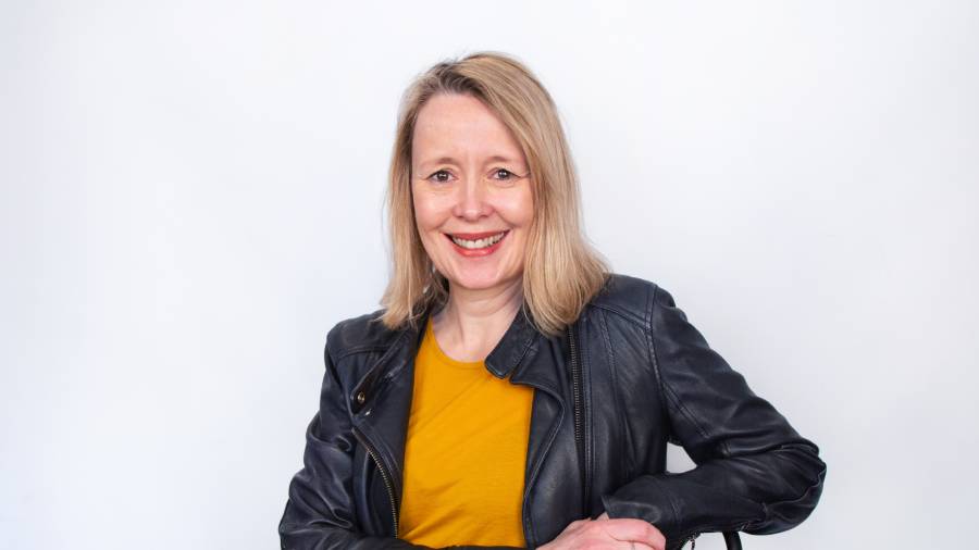 A woman with blonde hair is smiling at the camera. She is wearing a black leather jacket over a yellow top, exuding confidence and approachability—qualities essential in personnel management. The background is plain white. A woman with blonde hair is smiling at the camera. She is wearing a black leather jacket over a yellow top, exuding confidence and approachability—qualities essential in personnel management. The background is plain white.